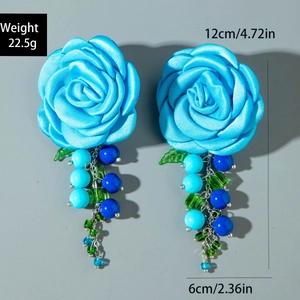 Dettaglio di grandi orecchini a fiore in tessuto blu con nappine di perline e misure
