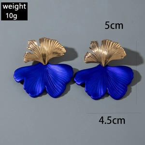 Dettaglio di orecchini a foglia di ginkgo con sfumatura blu-viola e oro lucido