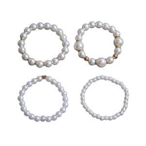Ensemble de 4 bracelets en perles élégants avec breloques cœur et perles dorées sur blanc