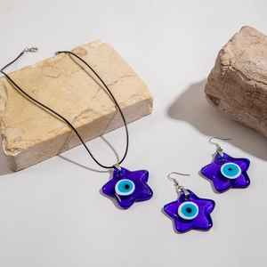 Blue glass evil eye star pendant necklace and earrings set on a natural stone base