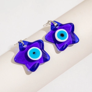 Detailed view of star-shaped blue evil eye earrings with silver hooks on a display