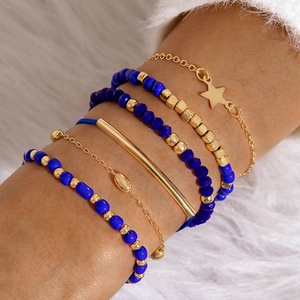 Vue détaillée d'un ensemble de 6 bracelets bohèmes à perles avec étoiles dorées sur peluche