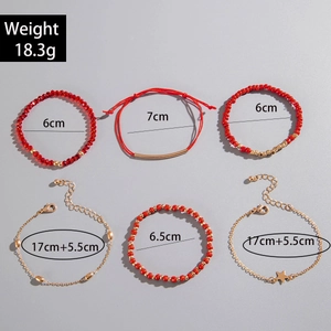 Détail d'un ensemble de 6 bracelets avec perles rouges, chaînes dorées et pendentifs étoile