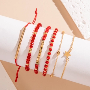 Détail de cinq bracelets en perles rouges et dorées avec un pendentif en forme d'étoile