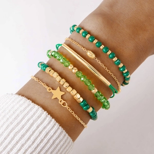 Détail du lot de 6 bracelets bohèmes à perles vertes et étoiles dorées sur un poignet