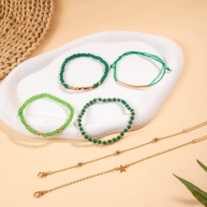 Détails de bracelets en perles vertes et breloques étoiles dorées sur plateau en céramique