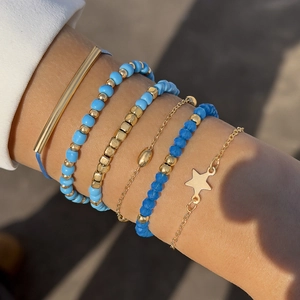 Vue détaillée des bracelets bohèmes superposés avec perles bleues et breloque étoile