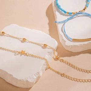Détail d'un ensemble de bracelets bohèmes avec pendentif étoile dorée et perles bleues