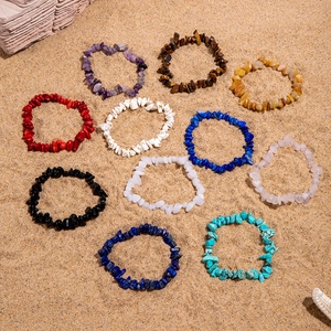 Collection détaillée de bracelets élastiques en pierres naturelles sur le sable