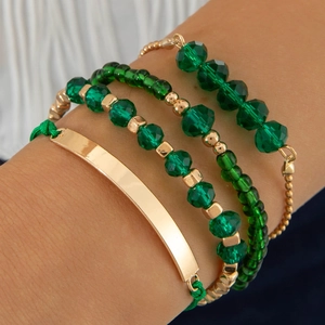 Détail d'un ensemble de quatre bracelets en perles de cristal vert et métal doré