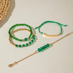 Vue détaillée de bracelets bohèmes avec perles vert émeraude et dorées en couches