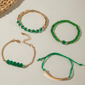 Détail d'un ensemble de quatre bracelets en perles vertes et métal doré tissé