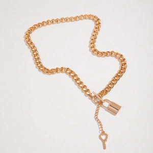 Detail of chunky gold chain necklace with padlock pendant and heart key charm toggle clasp