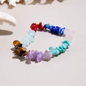 Détail d'un bracelet élastique arc-en-ciel composé de divers éclats de pierres naturelles