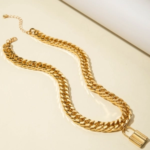 Macro detail of golden Cuban link necklace showing the adjustable clasp and lock pendant
