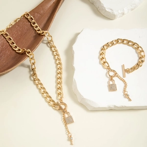 Macro shot of gold chunky chain necklace with iced-out lock and key pendant detail