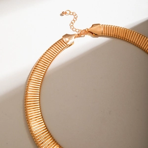 Detail of gold ribbed choker featuring textured snake chain and lobster clasp closure
