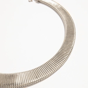 Detail of silver geometric choker necklace with modern vertical ribbed texture finish