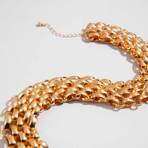 Macro detail of chunky gold braided necklace showing metallic texture and adjustable chain