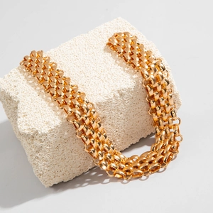 Macro detail of multi-row gold chain links featuring textured woven metal craft and glossy finish