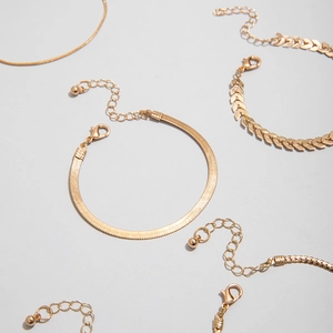 Detail of gold-plated snake chain and herringbone textured link bracelets with lobster clasps