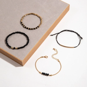 Lot de quatre bracelets minimalistes en perles noir et or avec corde tissée et tubes