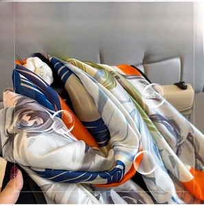 Detail of breathable satin scarf featuring tropical leaf prints and silky texture
