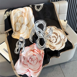 Detailed view of silk-like scarf with large pink camellia prints on black background