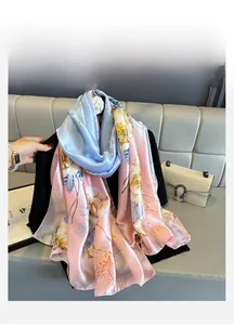 Close-up of elegant blue and pink gradient satin scarf with floral silk texture detail