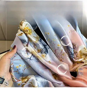 Detailed view of large floral print on silky blue and pink gradient fabric scarf