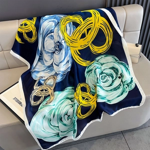 Detailed texture of silk scarf with floral prints and geometric rings on leather background