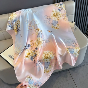 Detailed texture of gradient silk scarf featuring yellow floral patterns and butterflies