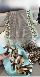 Detail of geometric chain print scarf with mint green edges and smooth silk-like finish