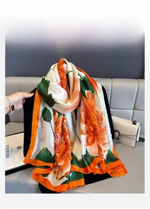 Detail of silk-satin scarf featuring orange peony floral print and bright orange borders