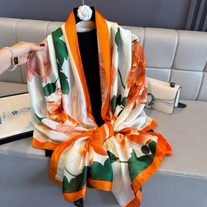 Elegant silk-like scarf with orange lotus print and bright orange rolled edges