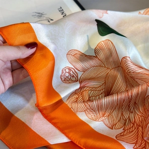 Elegant silk-like floral scarf with orange lotus print and lightweight satin texture