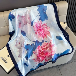 Detailed texture of blue silk scarf with pink lotus print and navy blue borders