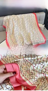 Details eines Seidenschals mit geometrischen Buchstabenmustern und feinen Säumen