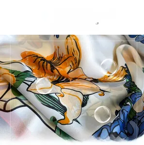 Detail of silk-satin scarf featuring elegant lily floral print and smooth texture
