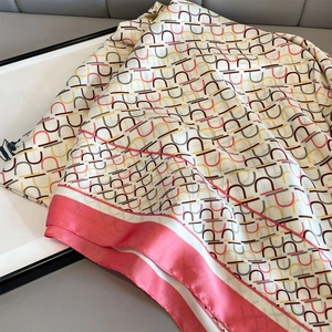 Detailansicht eines Seidenschals mit geometrischen Hufeisenmustern und rosa Rand