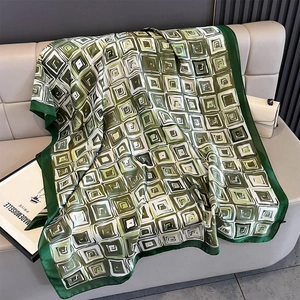 Detail of green retro geometric print silk scarf with a lustrous smooth texture