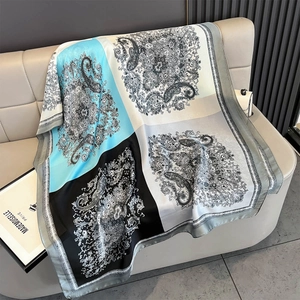 Detail of silk-like paisley scarf with contrast sky blue and black color blocks on leather