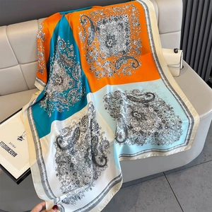 Close-up of silk-like scarf featuring paisley patterns and color-block patchwork design