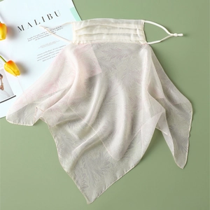 Detail of floral silk sun protection face mask with adjustable ear loops on green backdrop