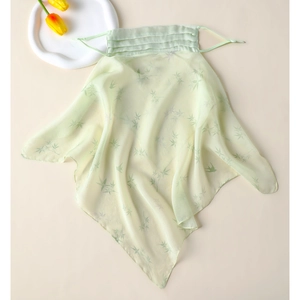 Detail of light green silk sun mask with bamboo leaf print and elastic ear loops