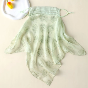 Detail of light green silk sun mask with delicate tree patterns and adjustable ear loops