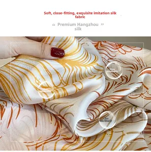Close-up of lightweight silk sunscreen shawl with feather print and smooth texture