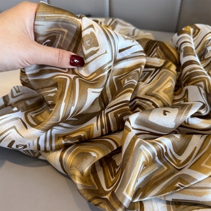 Detail of soft silk-like fabric with geometric prints showing drape and premium texture