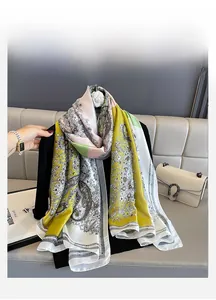Detail of silk-like scarf with paisley and baroque patterns draped over a black blazer