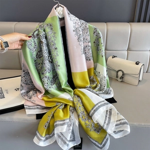 Elegant paisley faux silk shawl with contrast color splicing on a luxury sofa backdrop
